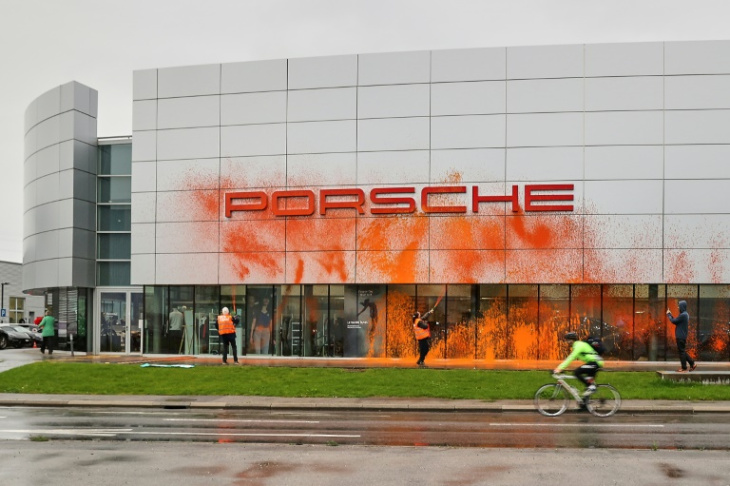 cuatro activistas climáticos rocían un concesionario porsche con pintura naranja en suiza