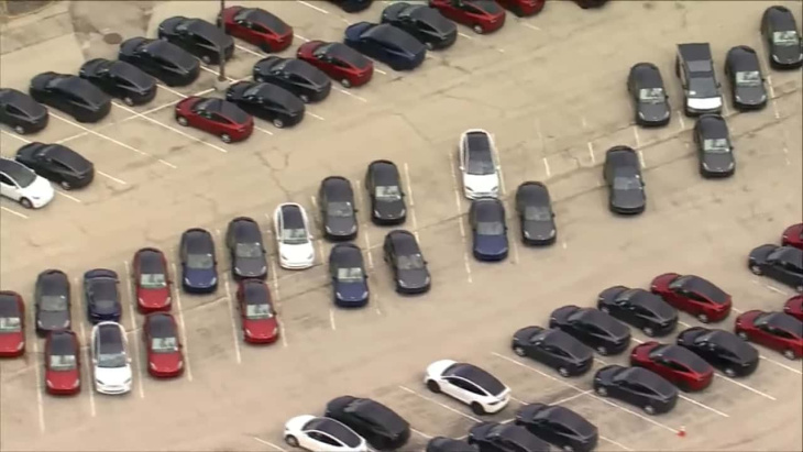 cientos de teslas esperan en el aparcamiento vacío de un centro comercial